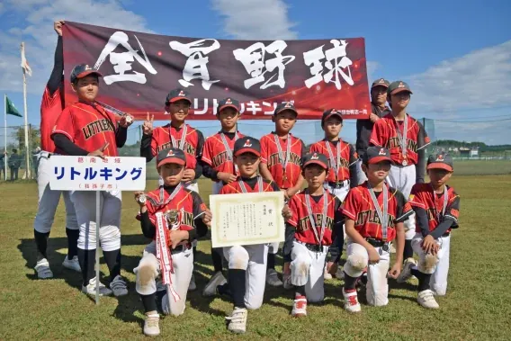 横断幕の前で賞状とトロフィーを持つリトルキングの選手たち